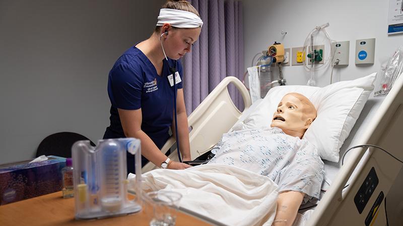 Nursing lab student with dummy